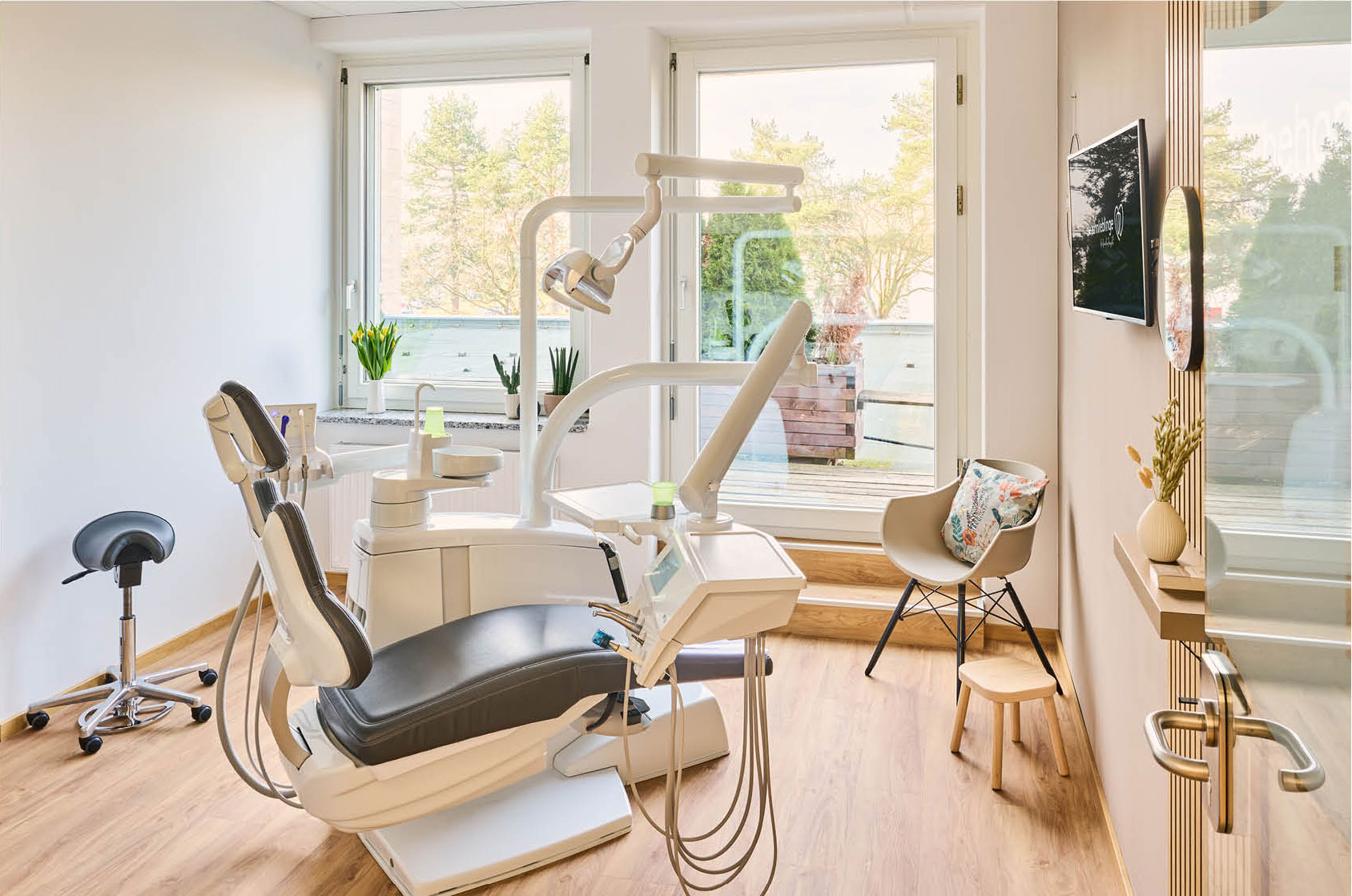 Der helle, warm eingerichtete Behandlungsraum der Zahnarztpraxis zahnlieblinge grenzt führt auf einen Balkon